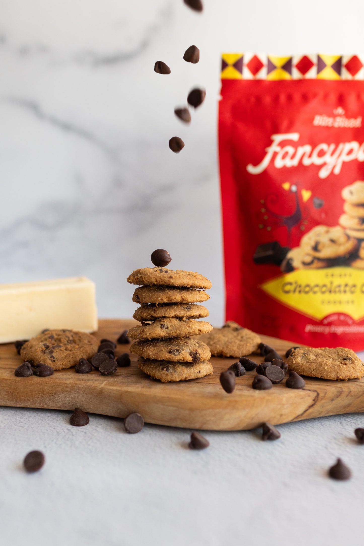 Stack of Fancypants crispy chocolate chip cookies with falling chocolate chips