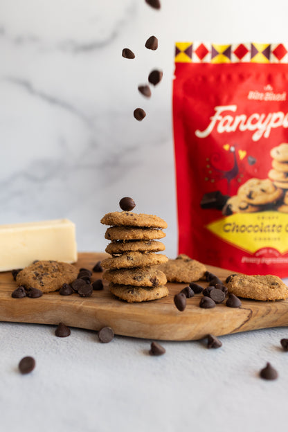 Stack of Fancypants crispy chocolate chip cookies with falling chocolate chips