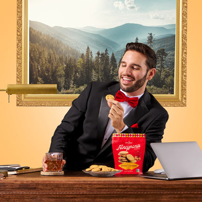 Man enjoying Fancypants crispy salted caramel cookies next to cookie pouch